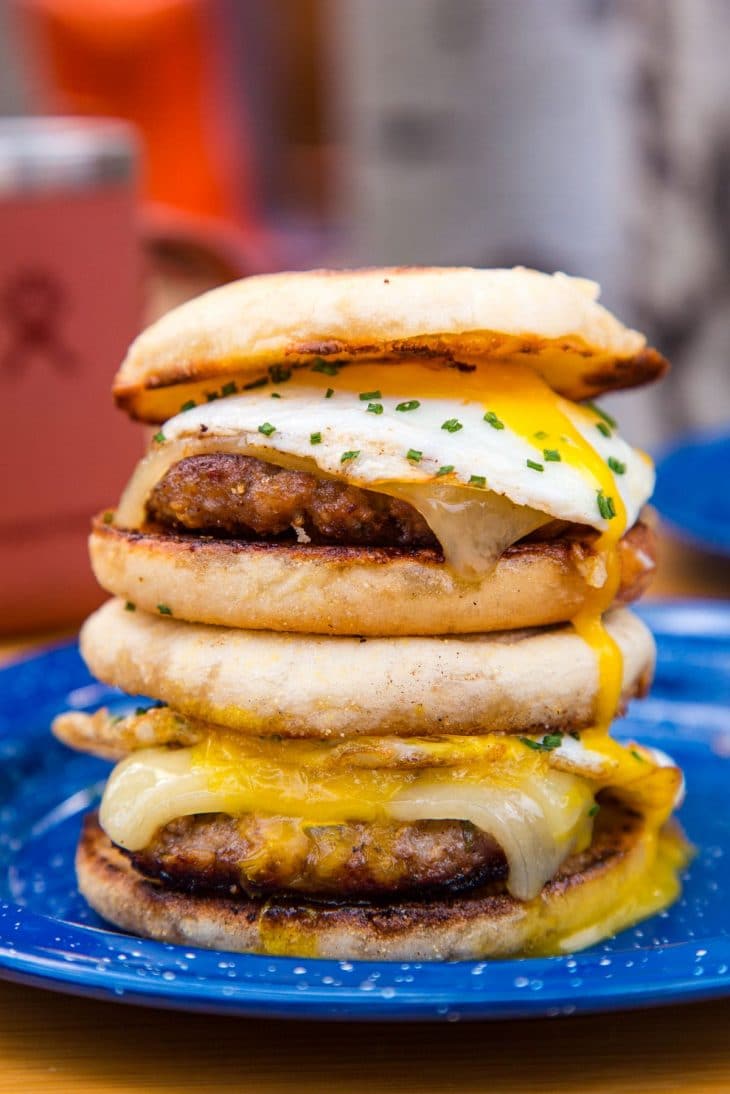 Side view of two sausage and egg sandwiches with runny yolks.
