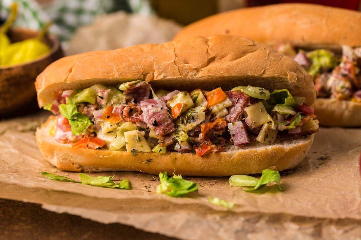 Chopped italian sandwich in a big bun on parchment paper.