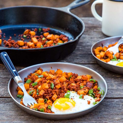 Sweet potato and chorizo hash with an egg on a plate.
