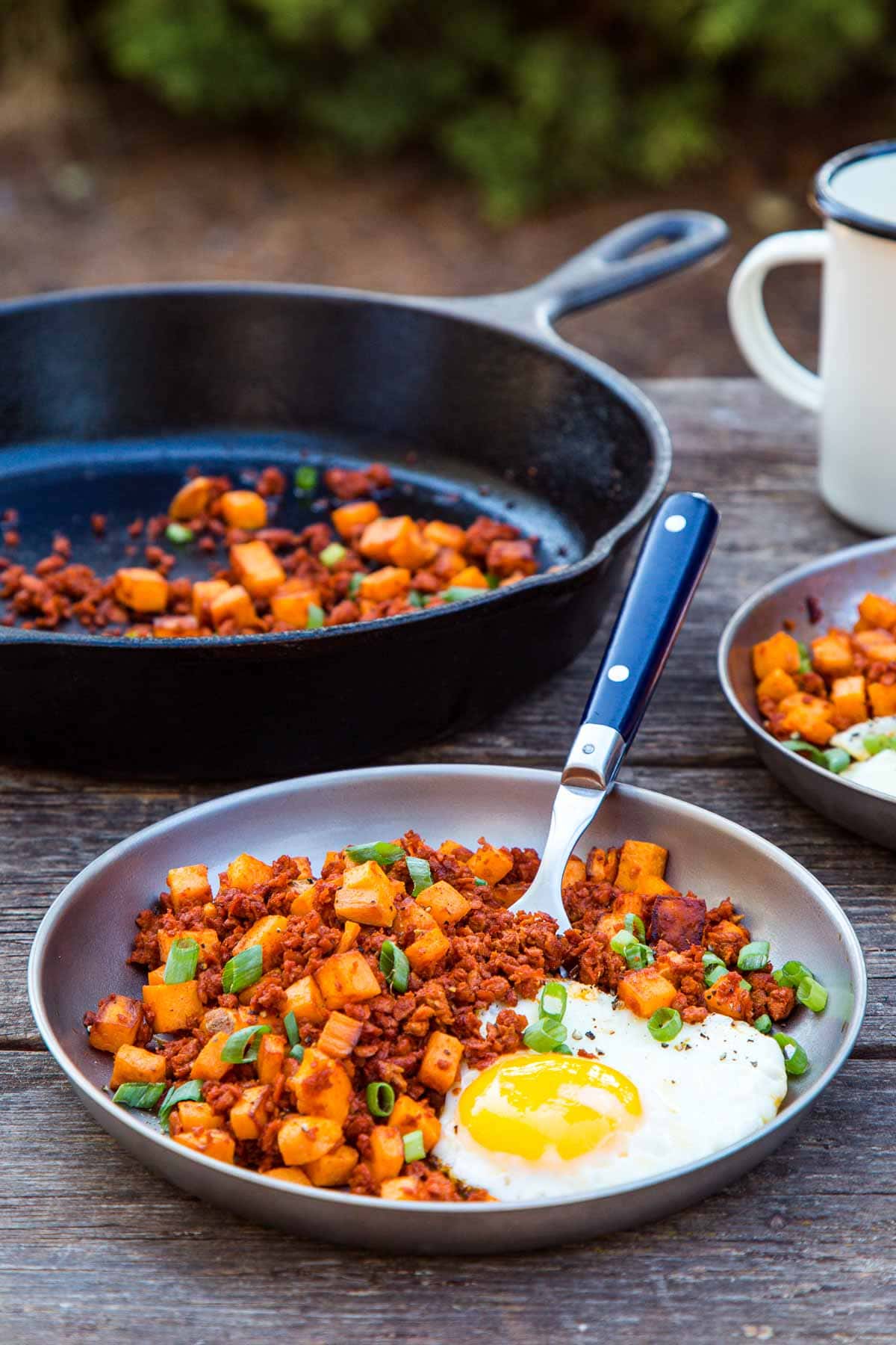 Sweet potato and chorizo hash with an egg on a plate.