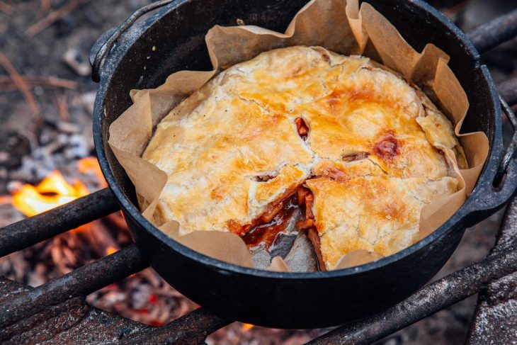 Apple pie in a Dutch oven with a slice taken out