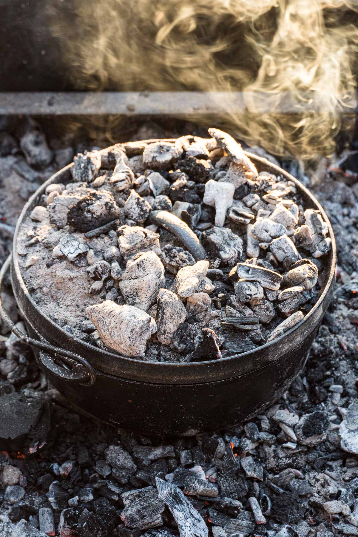 A dutch oven with coals on top of the lid.