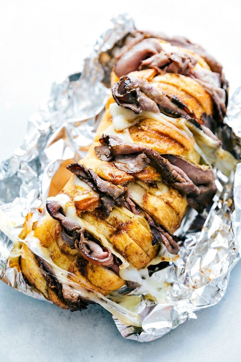 Slices of bread, meat, and cheese layered together in a foil pack.