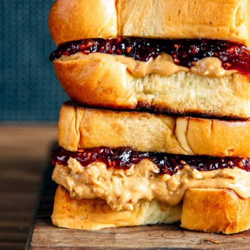 Brioche pb&j sandwich stacked on a wooden board