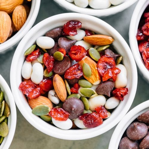 Almonds, pepitas, yogurt raisins, chocolate chips, and dried cranberries in a white dish