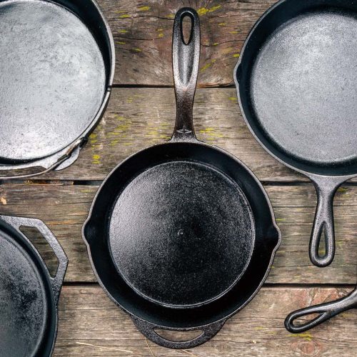 Cast iron skillets and Dutch oven on a wooden surface