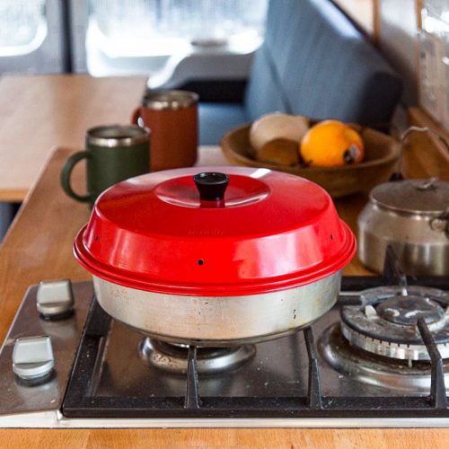 An Omnia oven on a stove burner in a campervan
