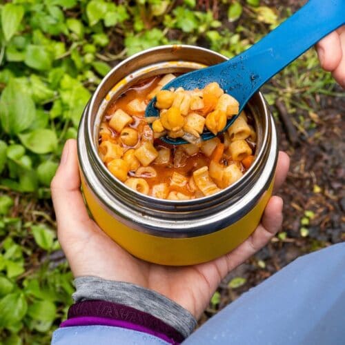 Megan holding pasta e ceci in an insulated container.