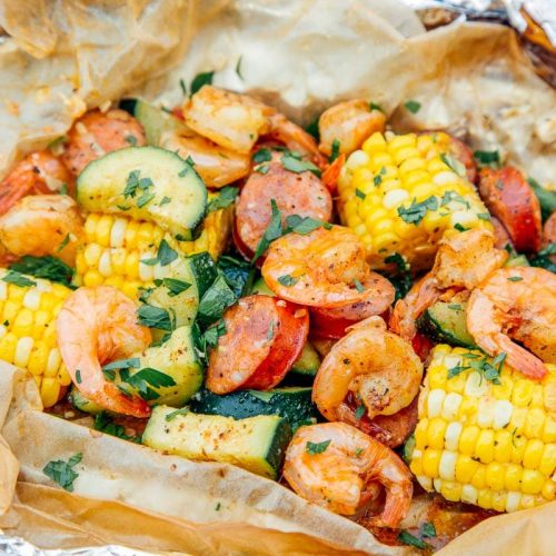 Close up of shrimp, corn on the cob, and sausage cooked in a foil packet