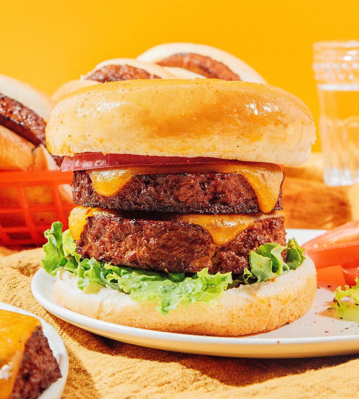 A plump double tofu cheeseburger with fresh lettuce on a toasted bun.