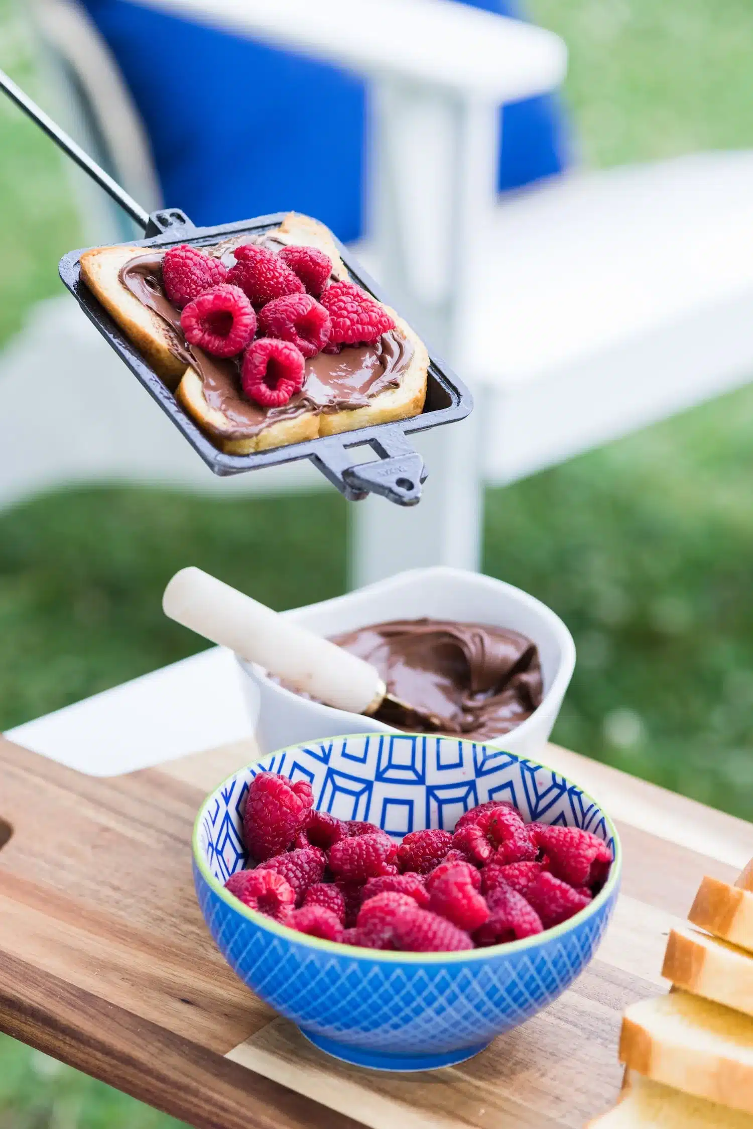 Nutella and raspberries on bread inside a pie iron.